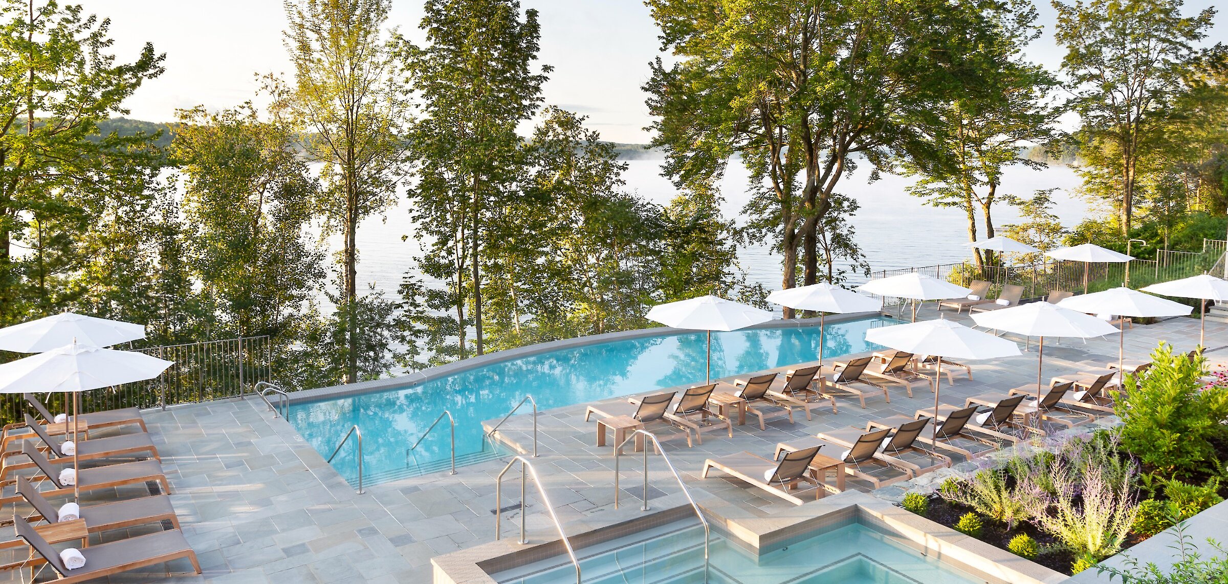 Vue de la piscine à débordement sur le lac devant l'hôtel