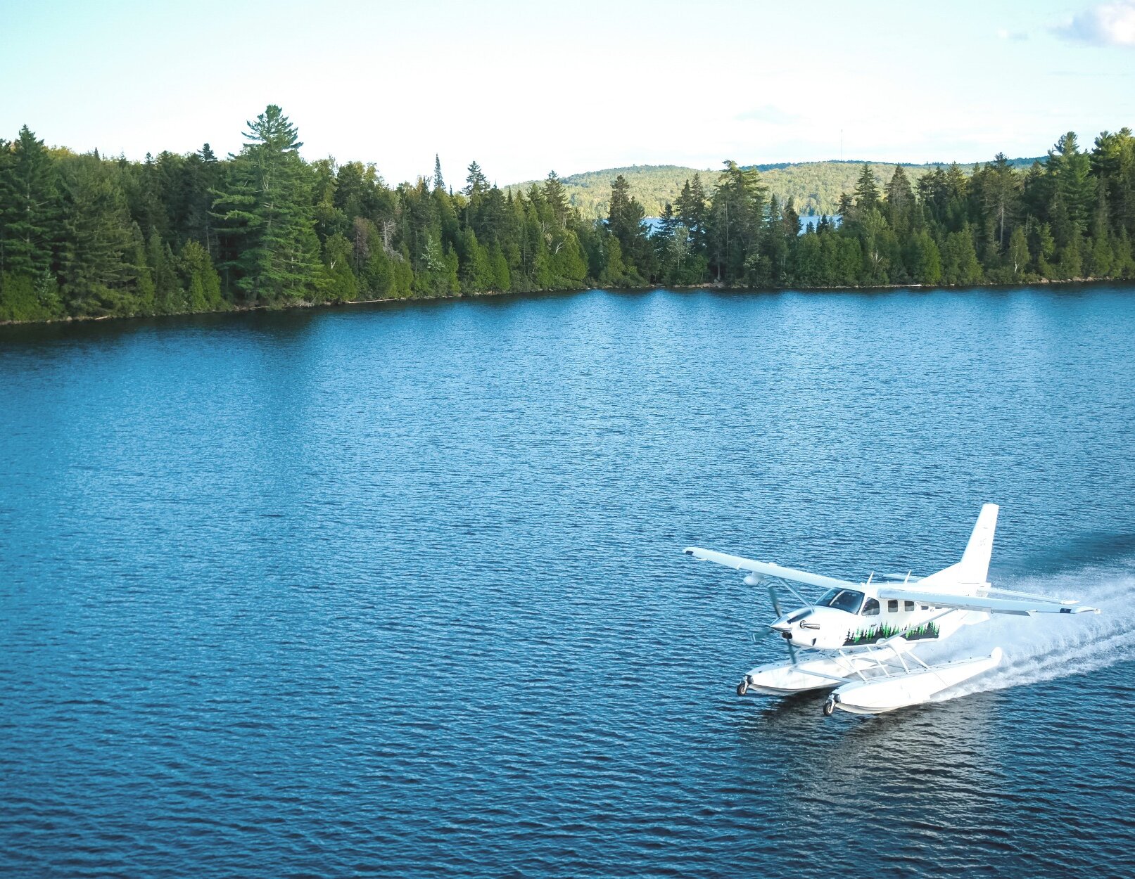 Atterrissage d'un hydravion sur le lac à proximité de la forêt